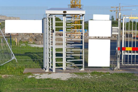 electronic access gates to the construction site. white plates for ad text or security announcements. Blank billboard and outdoor advertising. Mockup poster outside