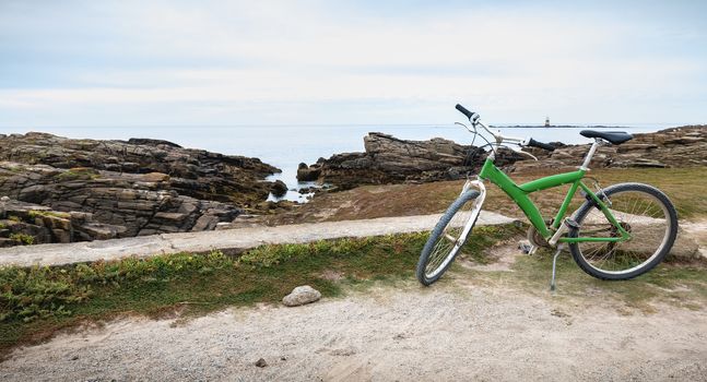 green bike parked near Pointe du But on the wild coast on Yeu island, France