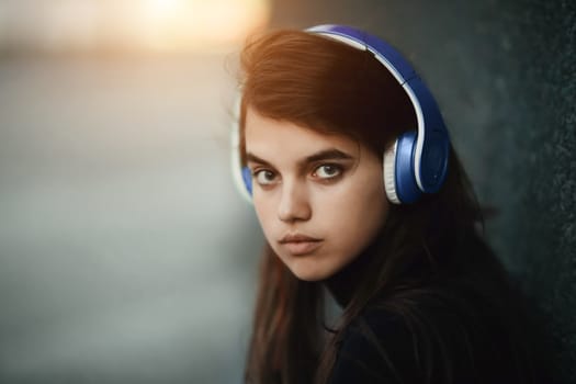 Web radios concept. Portrait of young beautiful girl listening music by headphones.