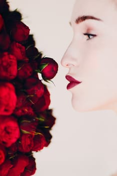 Beautiful woman model and red flowers bouguet.