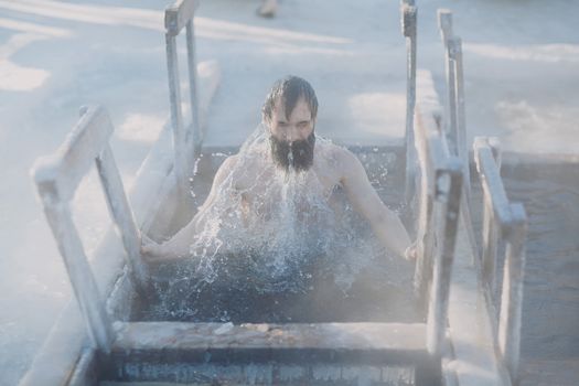 Tempered bearded man in the ice hole