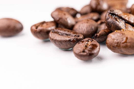 Macro view of roasted coffee beans on white background