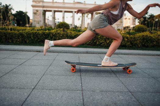 Young sporty woman riding on the longboard in the park