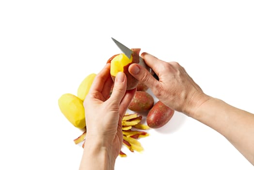 a pile of unpeeled potatoes and black potatoes peeling, white background, object isolated. potato and peeler. female hands peel potatoes with a knife.