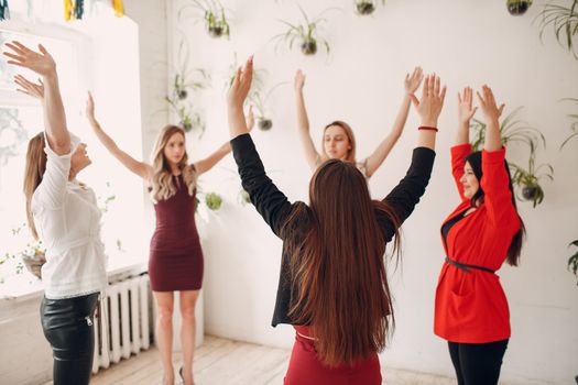 Team women doing exercises in office. Exercising females at work. Benefits of fitness and gymnastics  for employees and managers.