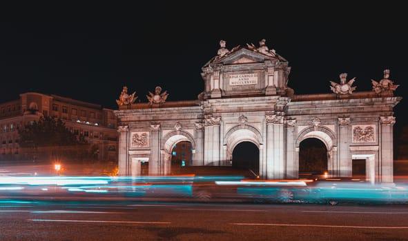 Night view of Puerta de Alcala with traffic lights in Madrid, Spain. Copy space available and 30 km per hour urban limit sign.