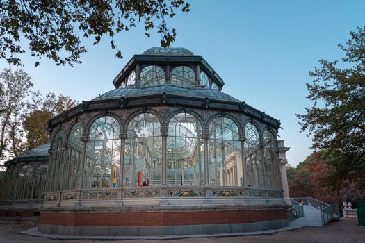 Sunset view of Crystal Palace or Palacio de cristal in Retiro Park in Madrid, Spain. The Buen Retiro Park is one of the largest parks of the city of Madrid, Spain