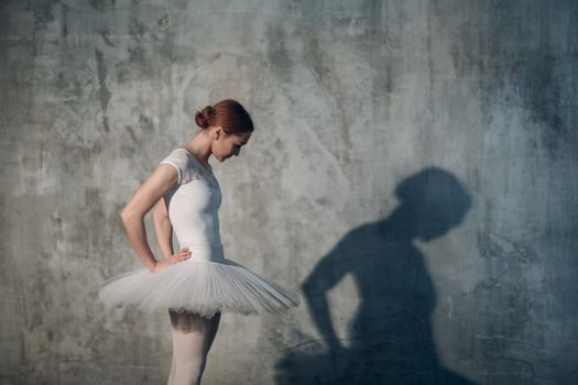 Ballerina female. Young beautiful woman ballet dancer, dressed in professional outfit, pointe shoes and white tutu.