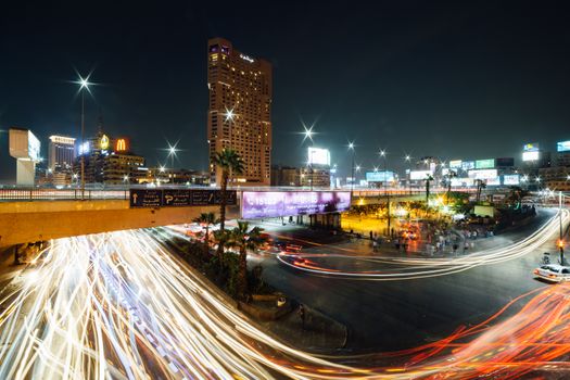 Cairo, Egypt - November 8, 2018: The busy Abdel Munim Riad square and bus station in central Cairo at night, long exposure with traffic light trails.