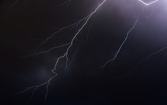 Night sky illuminated by lightning bolts