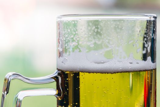 Close up of a glass of beer with foam on top.