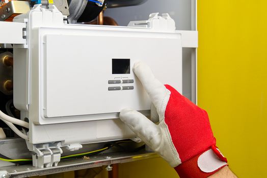 Repair of a gas boiler, setting up and servicing by a service department. Adjustment of gas boiler at domestic home. home repairs service concept