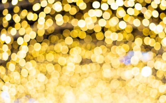 Golden beautiful blurred bokeh background. Glitter yellow light spots defocused. Suitable for copy space and background textures