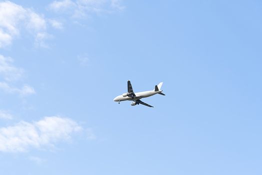 Jet plane flying in blue sky, preparing for landing