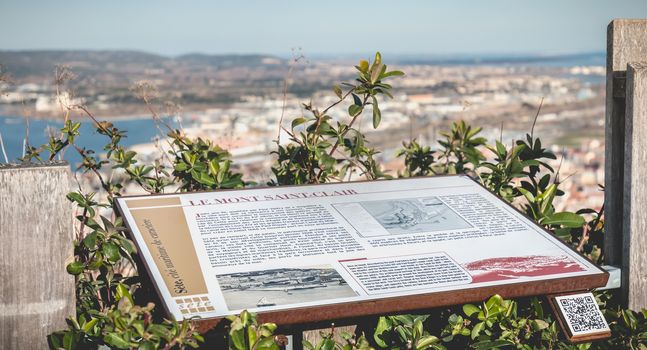 Sete, France - January 4, 2019: tourist plaque telling the story of Mont Saint Clair on the height of the city on a winter day