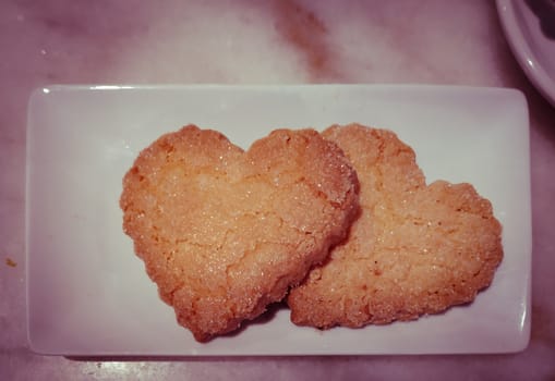Plate with sweet baking for Valentines day. Shortbread cookies in shape of heart top view.