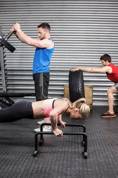 Fit people doing exercises at crossfit gym