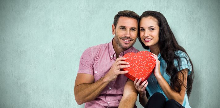 Happy couple with heart against blue background