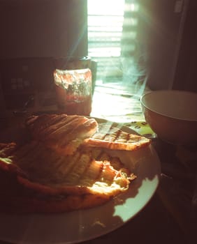 Freshly made breakfast, french croissant toasted in backlight. Orange and teal.