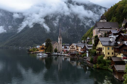 Scenic view of famous Hallstatt mountain village with Hallstatter lake. Foggy autumn sunset on Hallstatt lake. Location: resort village Hallstatt, Salzkammergut region, Austria, Alps. Europe.