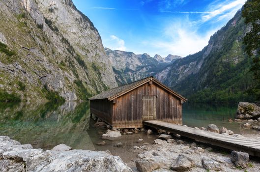 Beautiful view of traditional wooden boat house at the shores of famous Lake Obersee in scenic Nationalpark Berchtesgadener Land on a sunny day in summer, Bavaria, Germany