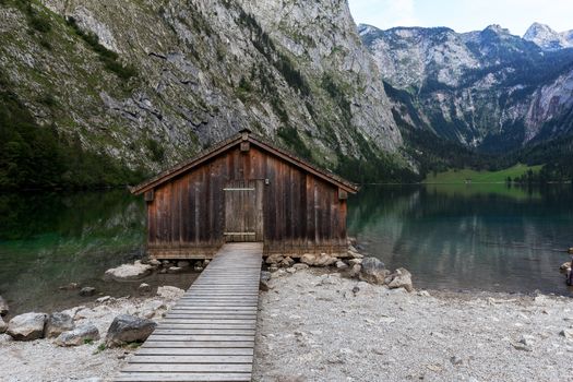 Beautiful view of traditional wooden boat house at the shores of famous Lake Obersee in scenic Nationalpark Berchtesgadener Land on a sunny day in summer, Bavaria, Germany