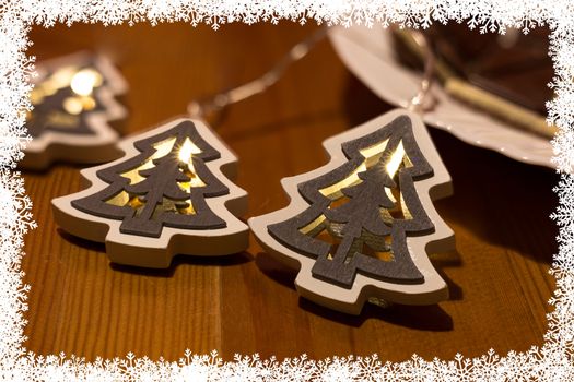 Christmas tree lights on a table and snowflakes frame