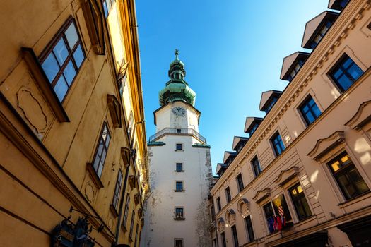 Street scene with the clock tower of the St. Michael's Gate in the old town of Bratislava, Slovakia