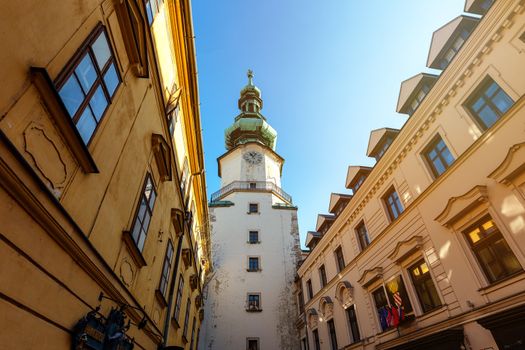 Street scene with the clock tower of the St. Michael's Gate in the old town of Bratislava, Slovakia