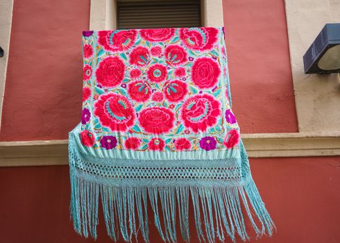 Balcony decorated with Manila shawl during the festivities of the Holy Week in Plasencia, Extremadura. Spain. It is traditional that the houses of the streets hang on their balconies Manila shawls in special days.