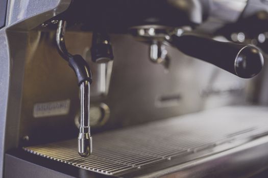 Close-Up of coffee machine in the coffee shop. Len blur effect. Soft focus and focus to Steam Milk stick. Process with vintage style