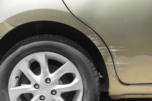 Car crash. Beside the deep green color car have scratch from damage on road. Close up scratch	