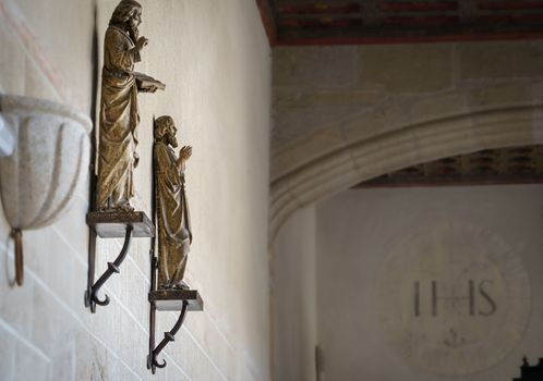 Religious figures hanging on the wall of an old convent cloister in Plasencia, Extremadura, Spain.