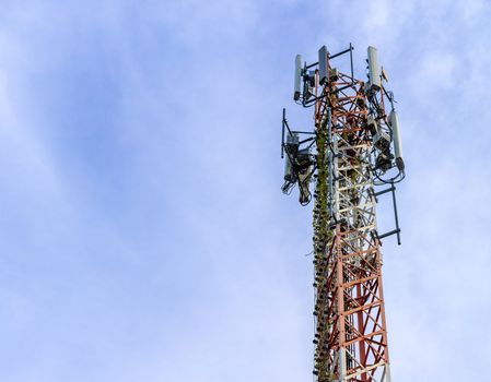 mobile phone communication and network signal repeater antenna tower with blue sky background