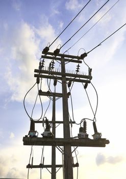 Energy and technology concept. High voltage electricity pole with eletric line and small transformers