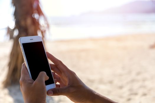 Close up hand man use mobile smart phone on the beach. Phone with black screen. With copy space for text or design