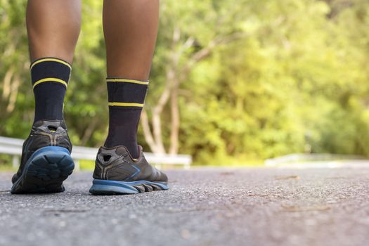 Man runner feet on road in Park workout wellness soft focus and focus close up on shoe 
