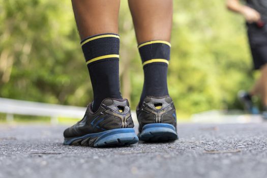Man runner feet on road in Park workout wellness soft focus and focus close up on shoe 