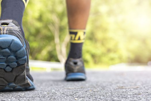 Man runner feet on road in Park workout wellness soft focus and focus close up on shoe  with copy space for text or design