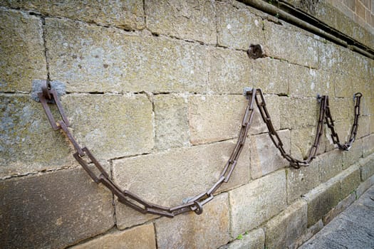 Heavy iron chain hung in the stone walls of the Cathedral of Plasencia, Spain. Is a Roman Catholic cathedral located in the town of Plasencia, Region of Extremadura, Spain. It is dedicated to the Virgin Mary.
