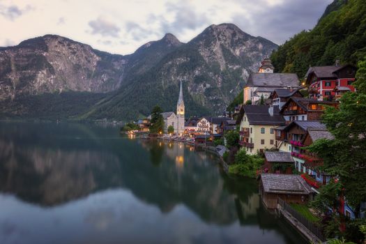 Scenic picture-postcard view of famous historic Hallstatt mountain village with Hallstattersee in the Austrian Alps in mystic twilight during blue hour at dawn in summer, Salzkammergut region, Austria