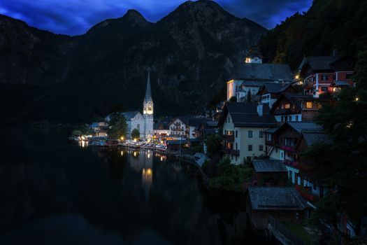 Scenic picture-postcard view of famous historic Hallstatt mountain village with Hallstattersee in the Austrian Alps in mystic twilight during blue hour at dawn in summer, Salzkammergut region, Austria