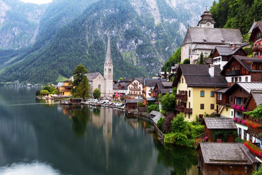 Scenic picture-postcard view of famous historic Hallstatt mountain village with Hallstattersee in the Austrian Alps in mystic twilight during blue hour at dawn in summer, Salzkammergut region, Austria