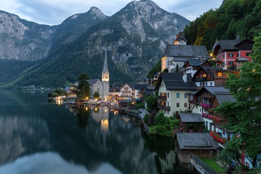 Scenic picture-postcard view of famous historic Hallstatt mountain village with Hallstattersee in the Austrian Alps in mystic twilight during blue hour at dawn in summer, Salzkammergut region, Austria