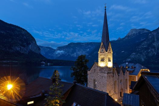 Scenic picture-postcard view of famous historic Hallstatt mountain village with Hallstattersee in the Austrian Alps in mystic twilight during blue hour at dawn in summer, Salzkammergut region, Austria