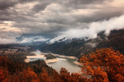 Cadore lake view on a cloudy day during beautiful autumn.