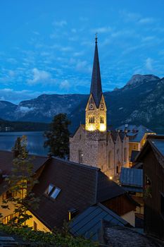 Scenic picture-postcard view of famous historic Hallstatt mountain village with Hallstattersee in the Austrian Alps in mystic twilight during blue hour at dawn in summer, Salzkammergut region, Austria