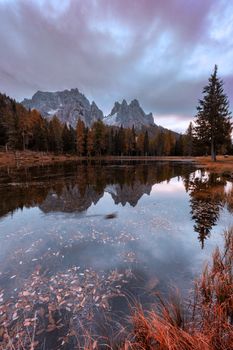 Beautiful late autumn with red colors at morning with mountain refection. Antorno lake, Italy, Europe.