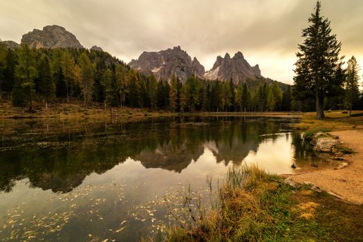 Cloudy morning at Antorno lake, warm morning colors and beautiful reflection. Italy, Europe