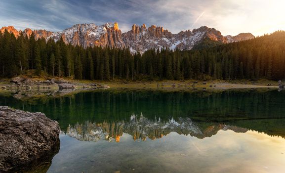 Sunset at Carezza lake with beautiful reflections of dolomites mountains